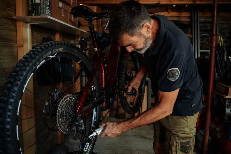 Dominique répare un VTT électrique dans l'atelier de Huelgoat Évasion